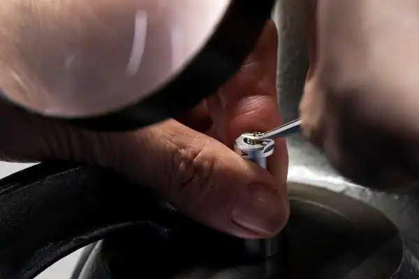 Close up of hand holding tiny metal pin